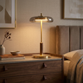 Lampe de table TOCRIS en laiton et verre ambré posée sur une commode de chambre